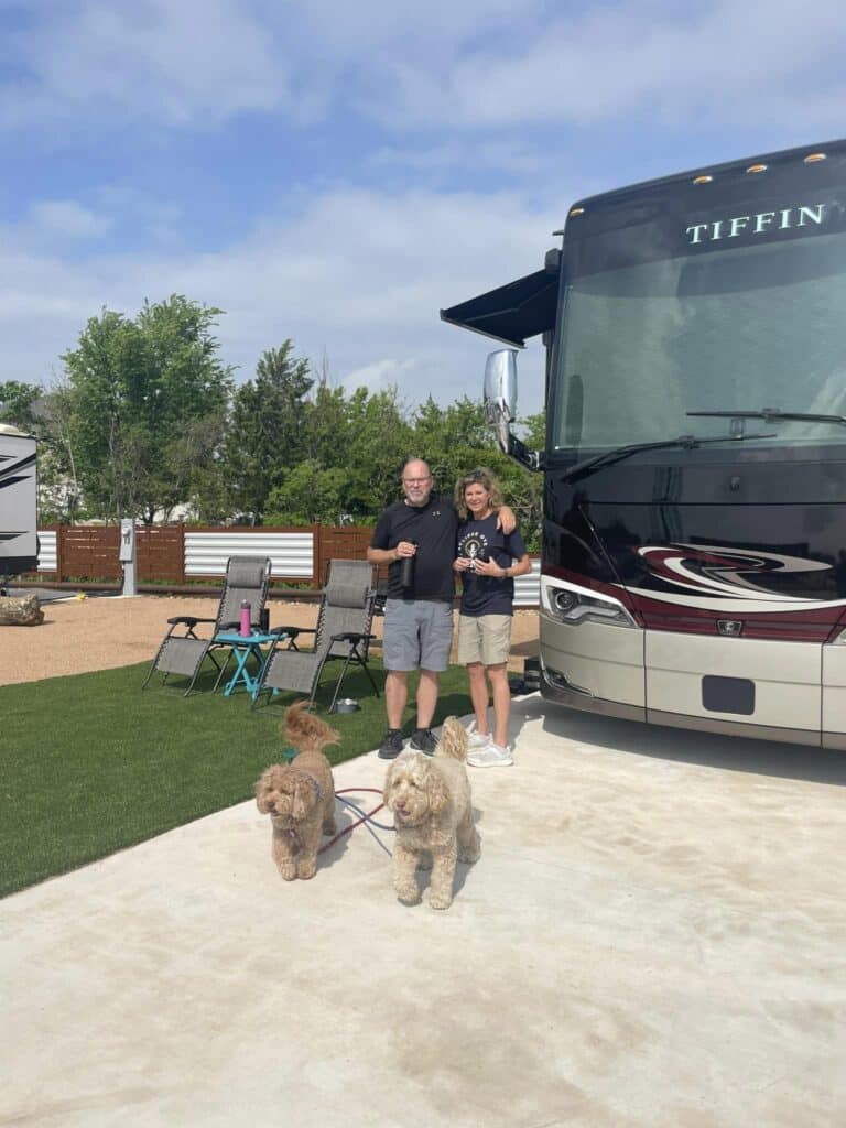 a couple having good time beside their skoolie at Ennis luxury RV resort