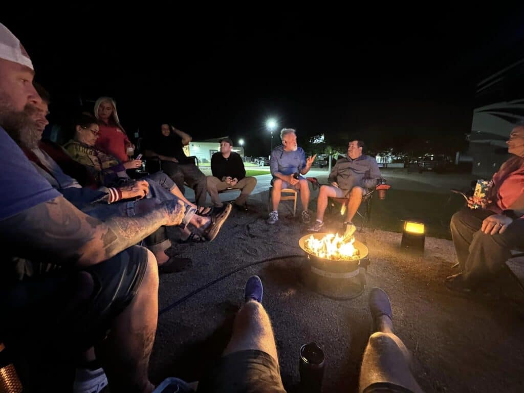 night scenes at Ennis luxury RV resort where people are sitting near bonfire